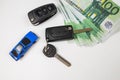 Car key euro money and blue toy car, car insurance, sale or rent Royalty Free Stock Photo