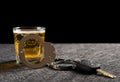 Car key and handcuffs in front of cup of beer