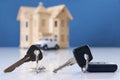 Car key and house keys with new automobile and home Royalty Free Stock Photo