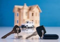 Car key and house keys with new automobile and home Royalty Free Stock Photo