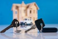 Car key and house keys with new automobile and home Royalty Free Stock Photo
