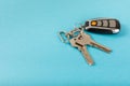 Car key with key fob on a colored background.