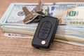 Car key lying on US 100 dollar bills Royalty Free Stock Photo