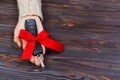 Car key with red bow in woomen hand on wooden background. Valentine`s Day concept Royalty Free Stock Photo