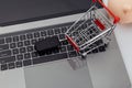 Car key and shopping trolley above laptop keyboard Royalty Free Stock Photo