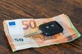 Car key on top of a pile of euro banknotes Royalty Free Stock Photo