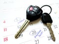 Car key on white calendar and made circle marked on date numbers. Royalty Free Stock Photo