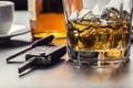 Car keys and glass of alcohol on table. Royalty Free Stock Photo