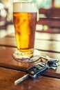 Car keys and glass of beer or distillate alcohol on table in pub or restaurant Royalty Free Stock Photo