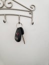 Car keys hanging on a key hook with a white background