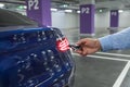 Car Keys. Male hand, holding car key opens blue car