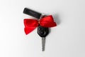 Car keys with red bow as present on white background. New car gift concept Royalty Free Stock Photo