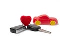 Car keys and red heart on the background of a red model car. concept of an expensive gift present to your beloved