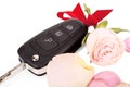 Car keys with ribbon and flowers as a gift isolated on white