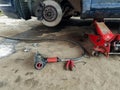 Car lifted up with hydraulical jack, pneumatic hammer on concrete floor, changing tire