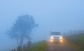 Car with lights on a foggy mountain road, mount Jaizkibel, Euskadi