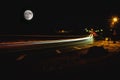 Car lights and giant moon