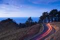 Car lights on the road of Mount Jaizkibel at sunset Royalty Free Stock Photo