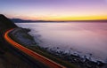 Car lights by the road by the sea at sunset Royalty Free Stock Photo