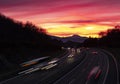 Car lights at sunset driving at high speed on the highway Royalty Free Stock Photo