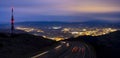 Car lights to the city at night and communications tower Royalty Free Stock Photo