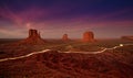 Car lights trails in Monument Valley at night.