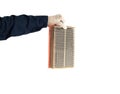 A car locksmith holds in his hand a dirty car air filter on a white background, isolate. Close-up, pollution