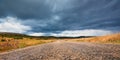 Car on long road. Lovely nature landscape. Dark stormy sky. Hilly terrain and summer countryside concept. Copy space Royalty Free Stock Photo