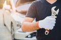 Car machanic holding wrench near car. Car maintenance concept Royalty Free Stock Photo