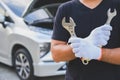 Car machanic holding wrench near car. Car maintenance concept Royalty Free Stock Photo