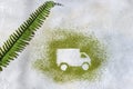 The car is made of green powder and a branch of a palm tree on a light background. Online shopping. Flowers delivery concept Royalty Free Stock Photo