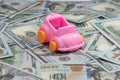 Car maintenance cost buy, rent, service, repair and insurance concept. pink toy car model on dollars Royalty Free Stock Photo