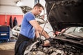 Car mechanic repairer service technician checks and repairs auto engine