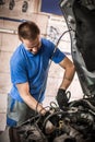 Car mechanic repairer service technician checks and repairs auto engine