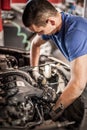 Car mechanic repairer service technician checks and repairs auto engine