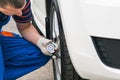 The car master checks the pressure in the wheel, close-up