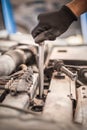 Auto mechanic repairer changing spark plugs on the car