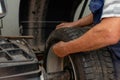 Car mechanic balancing car wheel on a computer machine balancer in auto repair service Royalty Free Stock Photo