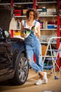 Car mechanic, woman studying the instructions for repair and adjustment of the car. Preparing for autotravel. Royalty Free Stock Photo