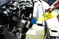 Car mechanic changes coolant on the vehicle