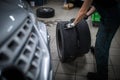 Car mechanic changind tires of a car in a repair shop