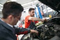 Profecional car mechanic changing motor oil at maintenance repair service station Royalty Free Stock Photo