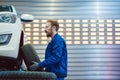 Car mechanic changing tire in his workshop Royalty Free Stock Photo