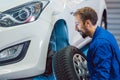 Car mechanic changing tire in his workshop Royalty Free Stock Photo