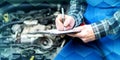 Car mechanic checking a car engine, geometric pattern