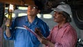 Car mechanic checking and maintenace car in service under supervision of senior mechanic Royalty Free Stock Photo