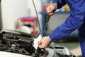 Car mechanic checking oil level