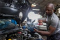 Car mechanic checking  oil quality the engine motor car Transmission and Maintenance Gear. car mechanic in an auto repair shop is Royalty Free Stock Photo