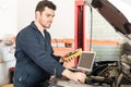 Car Mechanic Checking The Voltage Of Battery Using Voltmeter