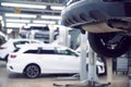 Car mechanic checks car on lift on Service station.